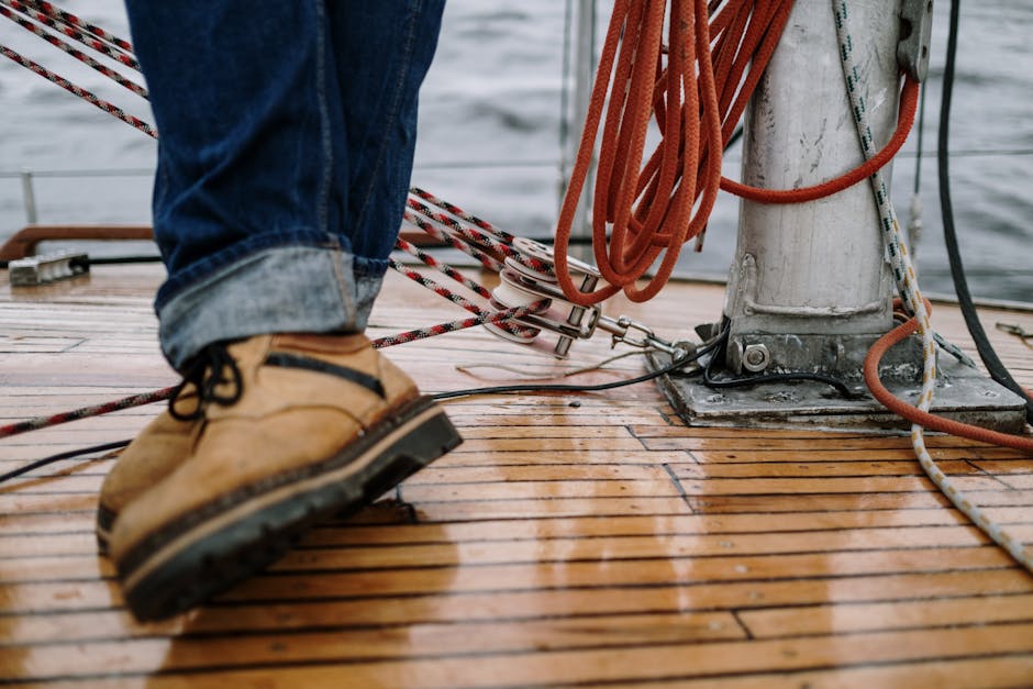 Detailed view of deck shoes and nautical ropes on a sailboat in overcast weather.